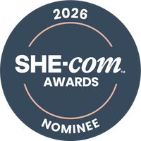 2026 SHE-COM Awards Nominee badge on a dark blue background